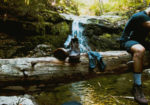 Image of hiker taking shoes off in forest