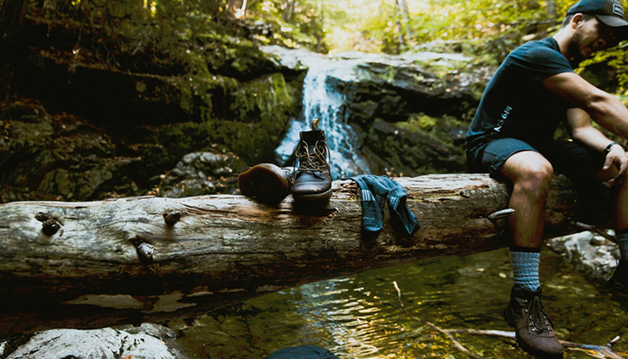 Image of hiker taking shoes off in forest