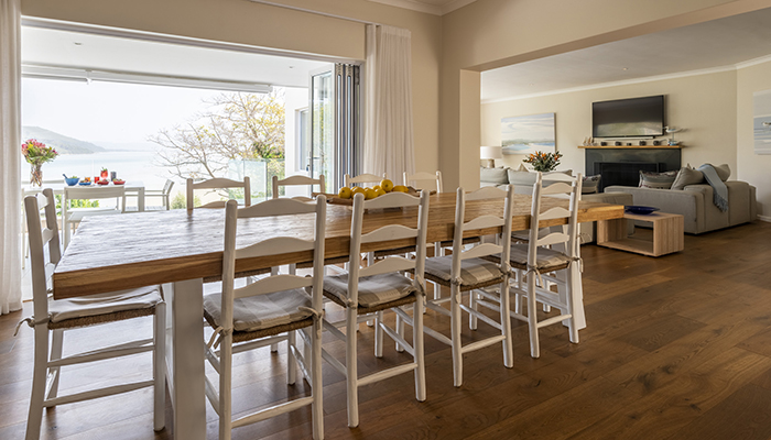 Spacious dining and living area with wooden floors and lagoon views at Number Eleven villa in Knysna