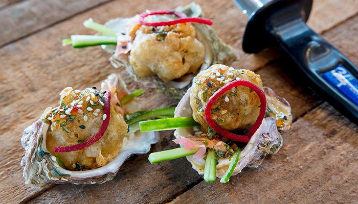 Three gourmet-style oysters served with pickled vegetables and tempura topping