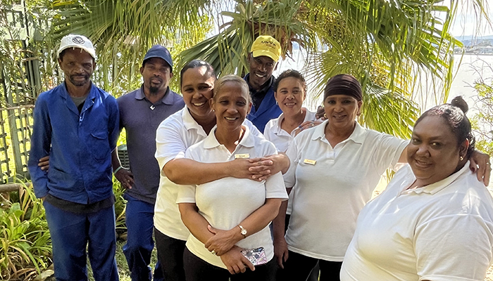 Smiling team members at The Milkwood Collection standing together near the lagoon