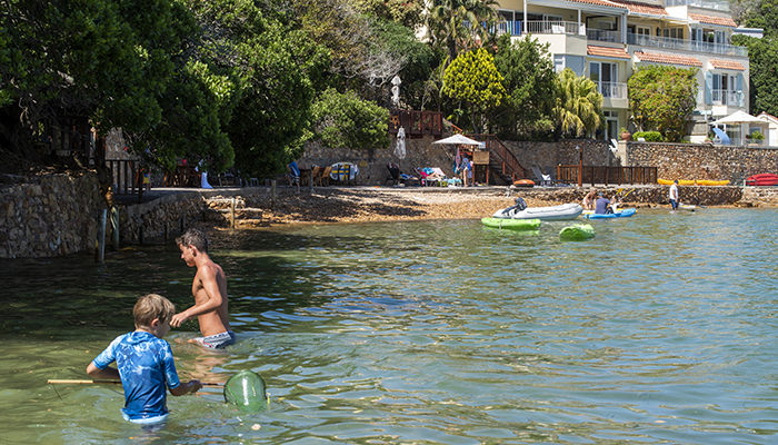 Children and guests swimming and kayaking in the lagoon at The Milkwood Collection