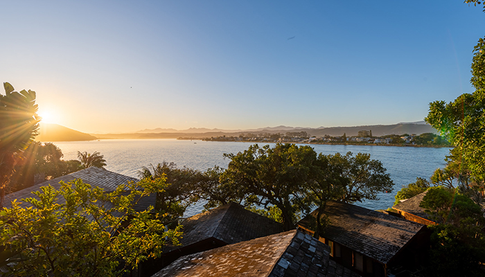 Sunset view over the Knysna lagoon and rooftops of chalets at The Milkwood Collection