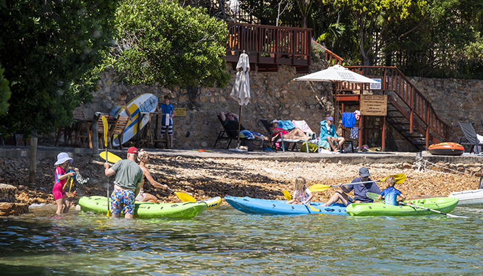 Families launching kayaks from Under Milkwood chalets