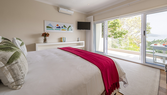 Bright bedroom with balcony and Knysna lagoon view at Number Eleven villa