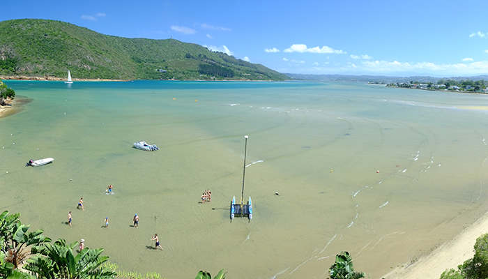 People swimming and wading in the Knysna Lagoon during low tide