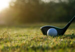 Golf club and ball on a course in warm morning light